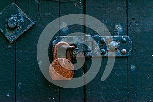 Old rusty padlock on wooden doors, old green destroyed door,safety