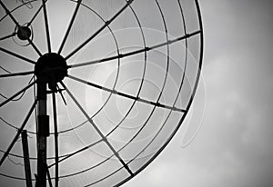 Old parabolic antenna on sky background