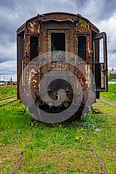 Old rusty passenger car abandoned on railway tracks