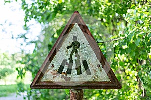 Old rusty pedestrian crossing roadsign