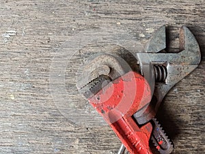 old rusty pipe wrench and adjustable wrench with wood texture background