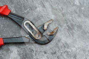 Old and rusty plumbing pliers on concrete floor