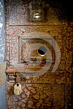 Old rusty prison door with a lock