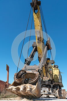 an old rusty quarry excavator is located on the territory of a mining quarry. an open method of mining