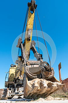an old rusty quarry excavator is located on the territory of a mining quarry. an open method of mining