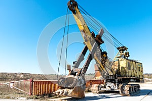 an old rusty quarry excavator is located on the territory of a mining quarry. an open method of mining