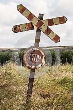 Old and rusty railroad sign with stop letters