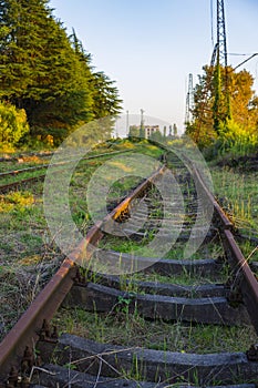 Old rusty rails of an abandoned railway leaving afar