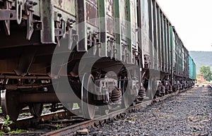 Old rusty railway cars stand on the tracks