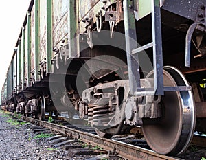 Old rusty railway cars stand on the tracks