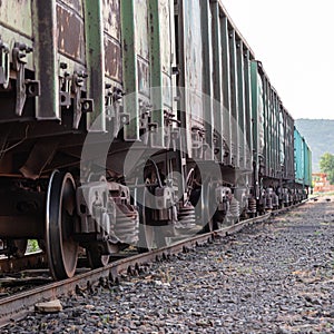 Old rusty railway cars stand on the tracks