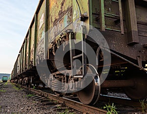 Old rusty railway cars stand on the tracks