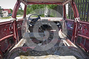 Old rusty red car inside view