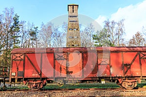 Old rusty red metal freight car on disused train tracks at old station