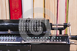 Old rusty retro calculator black standing on a wooden table