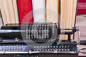 Old rusty retro calculator black standing on a wooden table