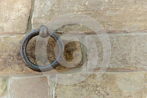 Old rusty ring fixed in a stone brick wall