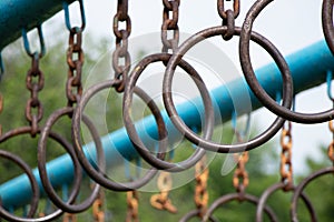 old rusty rings on a chain on a horizontal bar for gymnastics on the street, sports ground