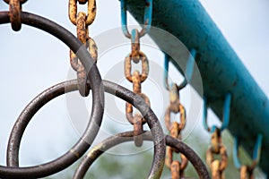 old rusty rings on a chain on a horizontal bar for gymnastics on the street, sports ground