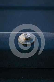 Old rusty roofing nail in metal sheet roof