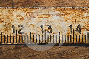 Old rusty ruler with black numbers on a working wooden table. vintage measuring tape close up. industrial background