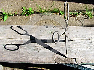 Old rusty scissors stuck in wooden board, stability of subject