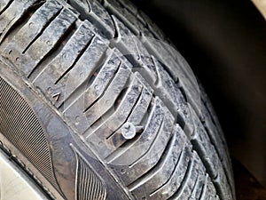 old rusty screw or nail inside a car tyre that caused a damage and the tire need to be fixed or replaced, car mechanic service