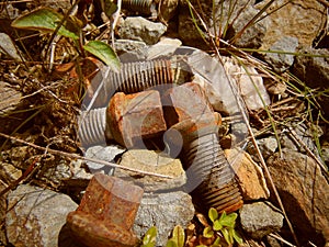 Old rusty screws laying on stone path