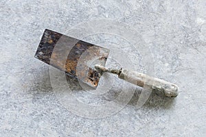 Old rusty shovel on a cement dusty floor
