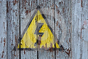 Old rusty sign danger high voltage on a wooden wall /