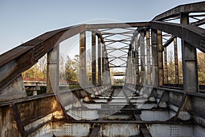 Old rusty solid ribbed tied arch bridge with railway already removed