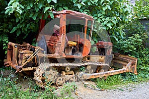 Old rusty soviet tractor, standing in the grass