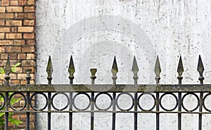 Old rusty spike fence against wall