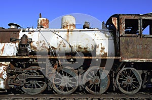 Old rusty steam locomotive on railway tracks