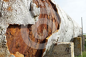 Old rusty tank with falling away pieces of rust