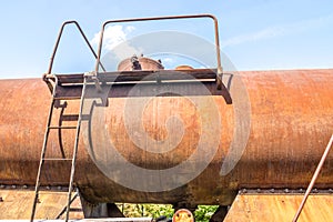 Old rusty, tank wagon, top detail with bridge, handles and valve