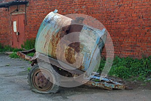 Old rusty tanker truck trailer on brick wall background.