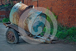 Old rusty tanker truck trailer on brick wall background