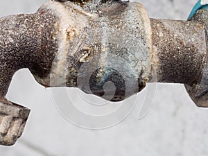 Old rusty tap size 1/2 inch with water drop  under it in garden