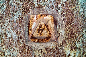 Old rusty tin surface with warning sign of high voltage