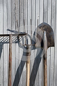 The old rusty tools, implements or household equipment on wooden background.