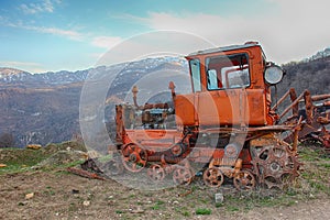 Old rusty tractor on the background of mountains