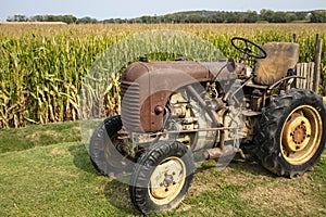 Old and rusty tractor on a corn field