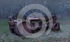 Old rusty tractor with metal barn