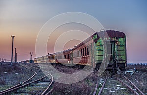 Old rusty train on the rails during sunset