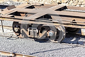 Old and rusty train wheels on a flat bed carriage