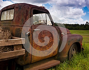 OLD RUSTY TRUCK IN A FIELD