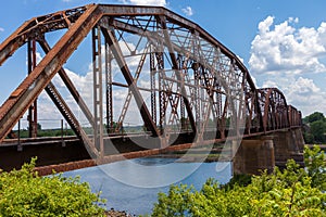 Old rusty truss railroad bridge over the Red River on the border