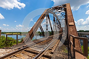 Old rusty truss railroad bridge over the Red River on the border