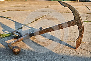 Old rusty two-legged anchor in the seaport